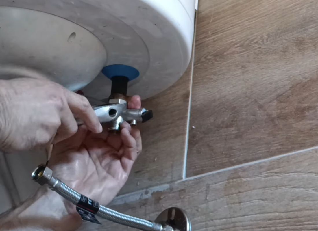 osoba menja sigurnosni ventil u bojleru